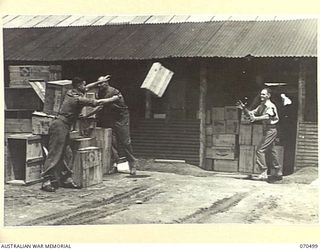 EGGY'S CORNER, PORT MORESBY AREA, PAPUA, 1944-02-19. PRIVATE REG ADAMS, (1), WITH PRIVATE WALKOM, (2), AND CORPORAL "APPLES" CASTERLEY, (3), PASSING STORES INTO THE CANTEEN AT THE 2/1ST GENERAL ..