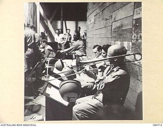 LAE, NEW GUINEA. 1944-11-23. AN AMERICAN DANCE BAND REHEARSING FOR A CONCERT TO BE GIVEN TO TROOPS OF NEW GUINEA FORCE. AUSTRALIAN CONCERT PARTIES AND UNITED STATES SPECIAL SERVICE BRANCHES HAVE ..