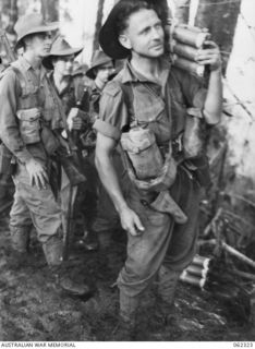 SHAGGY RIDGE, NEW GUINEA. 1943-12-27. A PRIVATE OF THE 2/16TH AUSTRALIAN INFANTRY BATTALION, 21ST AUSTRALIAN INFANTRY BRIGADE, WITH TRENCH MORTAR AMMUNITION ON HIS SHOULDER READY TO MOVE IN DURING ..