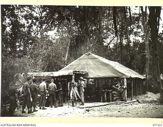 SCARLET BEACH, NEW GUINEA, 1944-03-19. ARMY COOKS BEING TRAINED IN FIELD COOKING AND CATERING AT THE 22ND INFANTRY BATTALION, 5TH DIVISION, ATTENDING GENERAL MESS PARADE FOR THE MIDDAY MEAL. THE ..