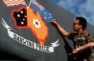 AMN Chazamn Knoezur of the 43rd Organizational Maintenance Squadron touches up the artwork that he designed and painted on the nose of a 43rd Bombardment Wing B-52G Stratofortress aircraft. The aircraft, which is being retired from U.S. Air Force service, will be placed on display in a museum at the Royal Australian Air Force (RAAF) Air Command Base in Darwin, Australia