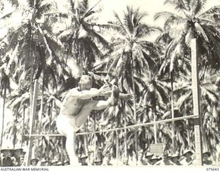 MILILAT, NEW GUINEA. 1944-09-03. QX55236 CORPORAL A.G. BAXTER CLEARING 4'-10" IN THE HIGH JUMP EVENT AT THE 5TH DIVISION SPORTS MEETING HELD IN CONJUNCTION WITH THE RELIGIOUS SERVICES TO ..