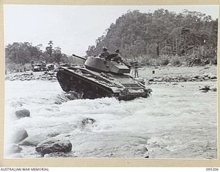 LARUMA RIVER, TOROKINA AREA, BOUGAINVILLE, 1945-08-14. AN M24 LIGHT TANK DURING FORDING AND BOULDER CROSSING TESTS CONDUCTED BY THE BRITISH WAR OFFICE TRIALS TEAM (TANKS)