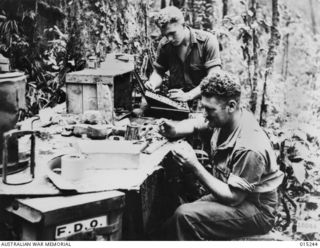 1943-07-09. NEW GUINEA. WAU-MUBO AREA. A DENTAL CLINIC POST IN A FORWARD AREA ALONG THE MUBO TRACK. USING THE WING OF A JAPANESE AIRCRAFT FOR A WORK BENCH, CORPORAL R. GOODALL, OF HOMEBUSH, N.S.W. ..