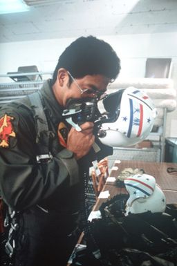 A member of the Hawaii Air National Guard checks his life support equipment before a flight
