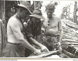 SATTELBERG AREA, NEW GUINEA. 1943-11-15. OFFICERS OF THE 2/24TH AUSTRALIAN INFANTRY BATTALION STUDYING THEIR POSITIONS ON A MAP OUTSIDE BATTALION HEADQUARTERS. LEFT TO RIGHT: VX14044 MAJOR P. G. ..
