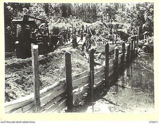 BOUGAINVILLE ISLAND. 1945-02-12. ENGINEERS OF THE 5TH FIELD COMPANY, ASSISTED BY PIONEERS OF THE 9TH INFANTRY BATTALION BUILDING A NEW BRIDGE OVER THE HUPAI RIVER. THE ORIGINAL BRIDGE WAS DESTROYED ..