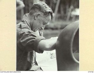 AT SEA. 1944. AN AUSTRALIAN SOLDIER ENJOYS A READ ABOARD THE COURIER BARGE OF THE 593 UNITED STATES BARGE COMPANY DURING THE TRIP BACK TO MADANG