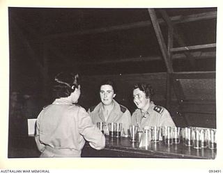 TOROKINA, BOUGAINVILLE. 1945-07-02. SHERRY BEING SERVED IN THE MESS ANTE-ROOM AT THE SISTERS' MESS/ 2/1 GENERAL HOSPITAL. A FORMAL DINNER WAS HELD IN CELEBRATION OF THE 43RD ANNIVERSARY OF THE ..