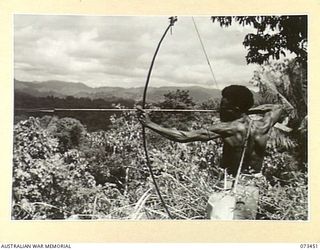 ALEXISHAFEN, NEW GUINEA, 1944-05-18. A NATIVE DEMONSTRATING TO MEMBERS OF AN INFANTRY PATROL HIS METHOD OF FIGHTING AGAINST JAPANESE FORCES