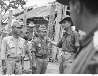 MISSION POINT, NEW GUINEA. 1945-11-09. LANCE CORPORAL DINA NAHT, INDIAN ARMY, IDENTIFYING A JAPANESE SOLDIER, AS ONE WHO MISTREATED HIM WHILE HE WAS A PRISONER OF WAR, DURING AN IDENTIFICATION ..