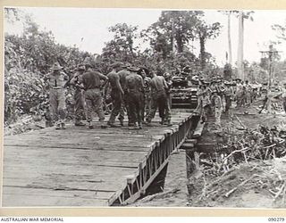 BOUGAINVILLE. 1945-03-30. MATILDA TANKS OF NO. 7 AND NO. 9 B SQUADRON, 2/4 ARMOURED REGIMENT, WAITING TO CROSS THE BRIDGE OVER COOMBES CROSSING, TOKO-DARARA ROAD, AS ENGINEERS OF 15 FIELD COMPANY, ..