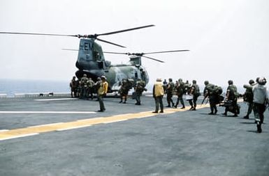 Marines of the 22nd Marine Expeditionary Unit (22nd MEU) file aboard a Marine Medium Helicopter Squadron 261 (HMM-261) CH-46E Sea Knight helicopter on the flight deck of the amphibious assault ship USS SAIPAN (LHA-2) during a rehearsal for Operation Sharp Edge. The SAIPAN is on station off the coast of Liberia