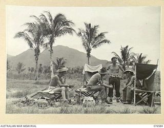 HOSKINS, NEW BRITAIN. 1944-10-10. TROOPS OF THE 36TH INFANTRY BATTALION RELAXING IN ONE OF THEIR OPEN AIR TENTS AT THE UNIT BEACHHEAD. IDENTIFIED PERSONNEL ARE:- V186173 PRIVATE W. LAWLESS (1); ..