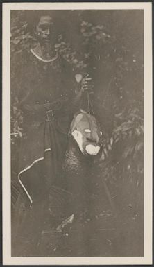 [Policeman from the Papua Armed Constabulary holding what looks like a decorated human head] Frank Hurley