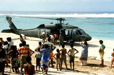 Villagers help unload supplies from a 53rd Aviation Battalion UH-60 Black Hawk helicopter following its arrival on the island of Savaii. Military personnel from the United States and other nations are providing such services to Savaii and the island of Upolu as part of disaster relief efforts in the aftermath of Cyclone Ofa