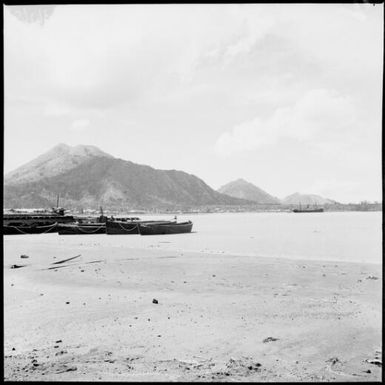 Whaleboats near a village and a Burns Philp ship in front of Mother and Daughter Mountains, Rabaul Harbour, New Guinea, 1937 / Sarah Chinnery