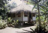 French Polynesia, women sitting on steps of home on Tahiti Island