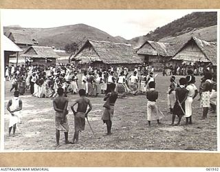 KILA KILA, PAPUA, NEW GUINEA. 1943-12-25. KEREMA BOYS EXECUTING A DANCE AT THE AUSTRALIAN AND NEW GUINEA ADMINISTRATION UNIT NATIVE LABOUR CAMP. THE DANCERS WEAR LONG TRAILS OF GRASS AND FLOWERS, ..