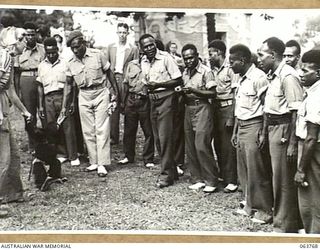 SYDNEY, NSW. 1944-01-26. AUSTRALIAN AND NEW GUINEA ADMINISTRATION UNIT NATIVES PLAYING WITH A TAME CHIMPANZEE AT THE TARONGA PARK ZOO