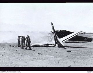 PAPUA, 1942-08-18. A TRANSPORT PLANE BURNING ON THE RUNWAY OF SEVEN MILE AERODROME, NEAR PORT MORESBY, AFTER A RAID BY TWENTY-FOUR JAPANESE BOMBERS. ONE MAN WAS KILLED AND THIRTEEN INJURED, FOUR ..