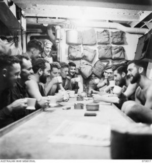 Sek Island, New Guinea. 1944-04-27. Personnel at supper aboard the corvette HMAS Bundaberg following a mess deck party. A total of eighty men from the 8th Infantry Brigade are being entertained ..