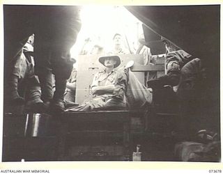 AT SEA, NEW GUINEA. 1944-05-31. VX157 LIEUTENANT COLONEL J G ROWAN, MC, (1), COMMANDING OFFICER OF THE 37/52ND INFANTRY BATTALION, SEATED IN AN AMERICAN LANDING BARGE IN FRONT OF THE BARGE CONTROL ..