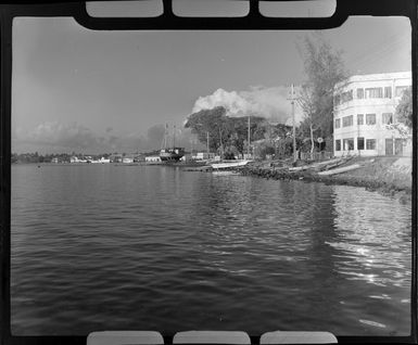 Grand Hotel, Tahiti, showing boat and small canoes on waterfront bank