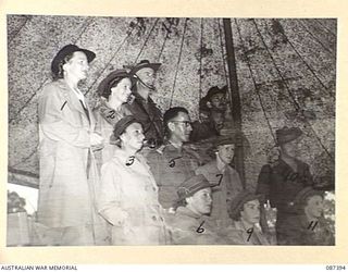 HERBERTON, QUEENSLAND. 1945-03-03. AUSTRALIAN ARMY NURSING SERVICE SISTERS FROM 2/6 GENERAL HOSPITAL AMONG 24 INFANTRY BRIGADE OFFICERS. THEY WATCH HEADQUARTERS 24 INFANTRY BRIGADE TROOPS DURING A ..