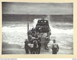 BOUGAINVILLE ISLAND. 1945-03-06. HEAVY SURF BREAKING OVER THE STERN OF A BARGE BEING UNLOADED BY TROOPS OF HEADQUARTERS, 7TH INFANTRY BRIGADE