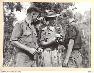 WEWAK AREA, NEW GUINEA. 1945-06-27. CAPTAIN A.J. MOONEY, REGIMENTAL MEDICAL OFFICER, 2/8 INFANTRY BATTALION (3), TREATS PRIVATE D.H. BURTON (4) FOR A MINOR CASUALTY AT THE MIDDLE KNOLL WHICH SERVED ..