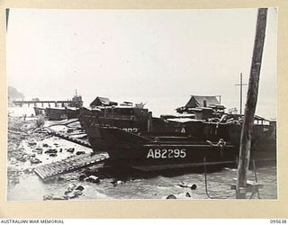 JACQUINOT BAY, NEW BRITAIN, 1945-08-31. THE VIEW, LOOKING WEST, OF AUSTRALIAN BARGES OF 53 PORT CRAFT COMPANY ROYAL AUSTRALIAN ENGINEERS, LINED UP ALONG THE BEACH