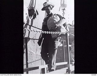 SYDNEY, NSW. 1946-05-09. QX63935 PRIVATE P. G. VINE, 22ND INFANTRY BATTALION, COMING DOWN THE GANGPLANK OF TROOPSHIP DUNTROON AFTER HER ARRIVAL AT CIRCULAR QUAY FROM KURE, MOROTAI AND RABAUL