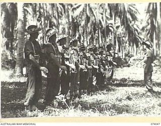 SIAR, NEW GUINEA. 1944-06-20. A PLATOON OF D COMPANY, 58/59TH INFANTRY BATTALION, RECEIVING INSTRUCTION IN THE HANDLING OF THE OWEN SUBMACHINE GUN IN THE UNIT TRAINING AREA. IDENTIFIED PERSONNEL ..