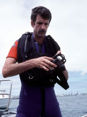 Commander Dave McCampbell commanding officer of Mobile Diving Salvage Unit 1 checks his gear before diving at the USS ARIZONA Memorial site. Salvage Unit 1 is participating in the joint Navy/Park Service project SeaMark, a surveying and charting effort to assess submerged cultural resources in the Pacific