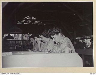 LAE, NEW GUINEA, 1945-05-16. AUSTRALIAN WOMEN'S ARMY SERVICE CIPHER OPERATORS WORKING IN THE CIPHER ROOM, SIGNALS, HEADQUARTERS FIRST ARMY. AUSTRALIAN WOMEN'S ARMY SERVICE PERSONNEL ARE TAKING OVER ..