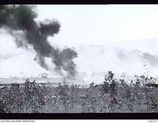 PAPUA. 1942-08-18. ALLIED BOMBERS EXPLODING ON SEVEN MILE AERODROME NEAR PORT MORESBY AFTER BEING HIT IN A BOMBING RAID BY TWENTY-FOUR JAPANESE BOMBERS