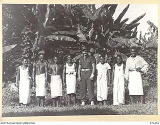 LAE, NEW GUINEA. 1944-05-24. NX151801 SERGEANT R KINNA (1), WITH MEMBERS OF THE KITCHEN STAFF OF THE SUPPLY AND STORES SECTION, AUSTRALIAN NEW GUINEA ADMINISTRATIVE UNIT