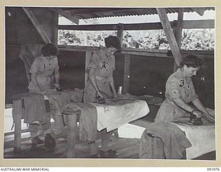 BOUGAINVILLE, 1945-04-19. AUSTRALIAN ARMY MEDICAL WOMEN'S SERVICE PERSONNEL PRESSING THEIR CLOTHES IN THE IRONING ROOM, 2/1 GENERAL HOSPITAL. IDENTIFIED PERSONNEL ARE:- PRIVATE I.V. TESCH (1); ..