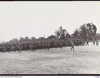 TOROKINA, BOUGAINVILLE. 1945-10-29. PERSONNEL OF 2/4TH ARMOURED REGIMENT, ROYAL AUSTRALIAN ENGINEERS AND THE SIGNALS SECTION MOVING TOWARDS THE SALUTING BASE WHERE THE COMMANDER IN CHIEF, ..