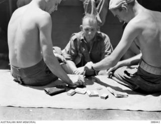 AT SEA. 1945-03-30. 2/48 INFANTRY BATTALION PERSONNEL PLAYING HOUSIE HOUSIE ABOARD THE VAN HEUTSZ DURING THE EMBARKATION OF HEADQUARTERS 26 INFANTRY BRIGADE TO MILNE BAY. IDENTIFIED PERSONNEL ARE:- ..