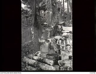 MOMOTE, LOS NEGROS ISLAND, ADMIRALTY ISLANDS. 1944-03-18. RAAF COOKS PREPARE A MEAL OUTDOORS USING JAPANESE OIL FOR FUEL AND A JAPANESE OIL DRUM AS A BOILER. COOKS EARNED THE PRAISE OF THEIR ..