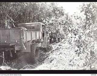 WAU-LABU ROAD, NEW GUINEA, 1946-01-09. MEMBERS OF 8 MECHANICAL EQUIPMENT COMPANY, ROYAL AUSTRALIAN ENGINEERS, TOWING A TIPPER TRUCK ALONG A TRACK SOME FIVE MILES FROM LABU