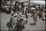 Mortuary ceremony: woman (l) adds to large bundle of banana leaves in ritual exchange