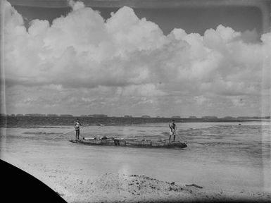 [An outrigger canoe on the water as seen from the beach]