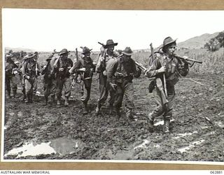 RAMU VALLEY, NEW GUINEA. 1944-01-15. A SECTION OF MACHINE GUNNERS OF THE 57/60TH INFANTRY BATTALION LEAVING BATTALION HEADQUARTERS TO TAKE UP A FORWARD POSITION BEYOND KESAWAI