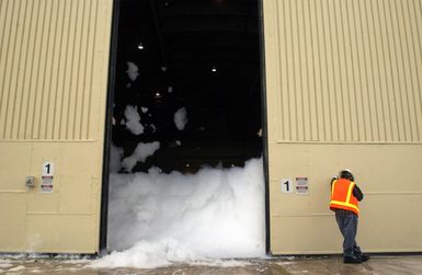 Doug Larsen a contractor with the Wolverine Fire Protection Company pulls an emergency lever to test a High Expansion (HI-EX) foam system used for fire protection inside aircraft hangars. The Jet Ex foam produced by the Ansul Corporation covers the hangar up to twelve feet high preventing the spread of fire