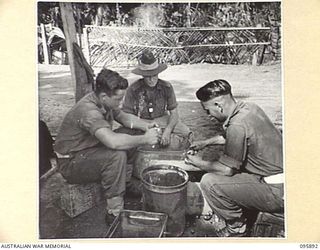 WIRUI BEACH, WEWAK, NEW GUINEA. 1945-09-04. MEMBERS OF 2/11 INFANTRY BATTALION ON KITCHEN DUTY PEELING ONIONS. IDENTIFIED PERSONNEL ARE:- PRIVATE R. FULLER (1); PRIVATE K.J. SCULLY (2); PRIVATE ..