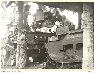 MADANG, NEW GUINEA. 1944-12-14. A REPLACEMENT ENGINE BEING LIFTED INTO A "MATILDA" TANK IN THE WORKSHOPS OF THE 2/4TH ARMOURED REGIMENT. IDENTIFIED PERSONNEL ARE: NX172935 CRAFTSMAN W.G. BOOTH (1); ..