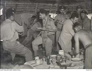 VIVIGANI, GOODENOUGH ISLAND, PAPUA. 1943-10-12. BEAUFIGHTER AIRCREW OF NO. 30 SQUADRON RAAF, GRIMY FACED AND TIRED EYED, EAT A MEAL ON RETURN FROM FIGHTING OVER RABAUL